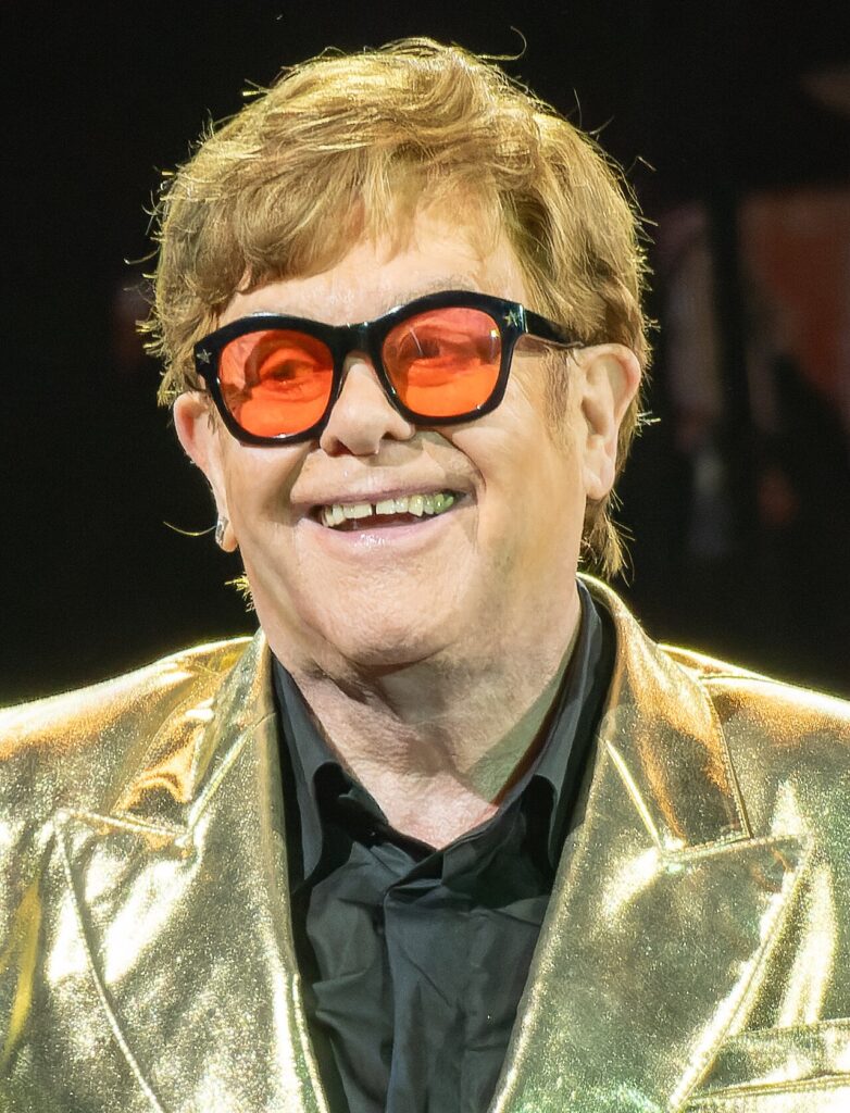 Singer Elton John performing on stage, one of the best-known LGBTQ+ singers of all time