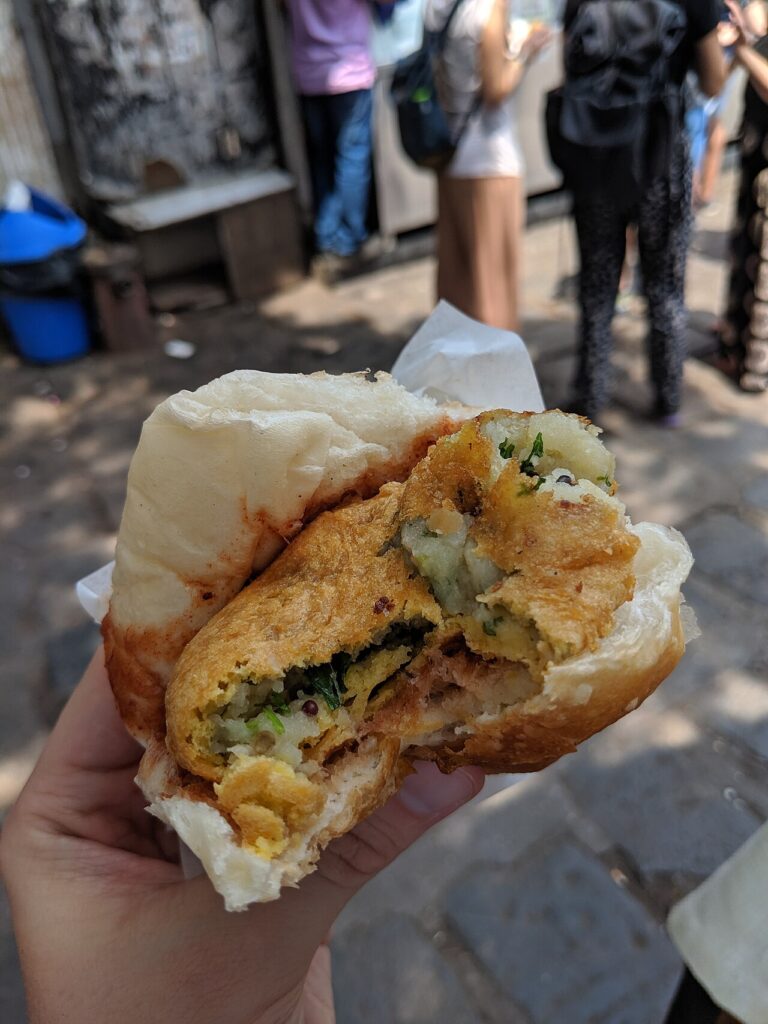 A plate of Mumbai vada pav served with green chutney and fried chillies