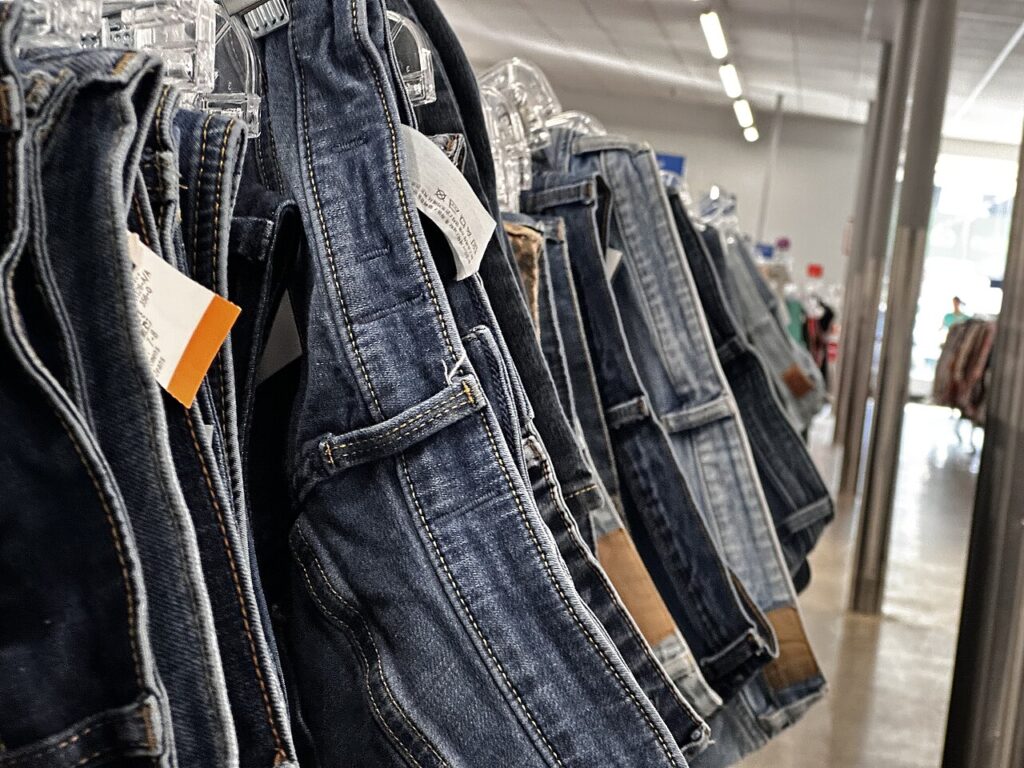 A rack of colourful second-hand and vintage clothes in a thrift shop